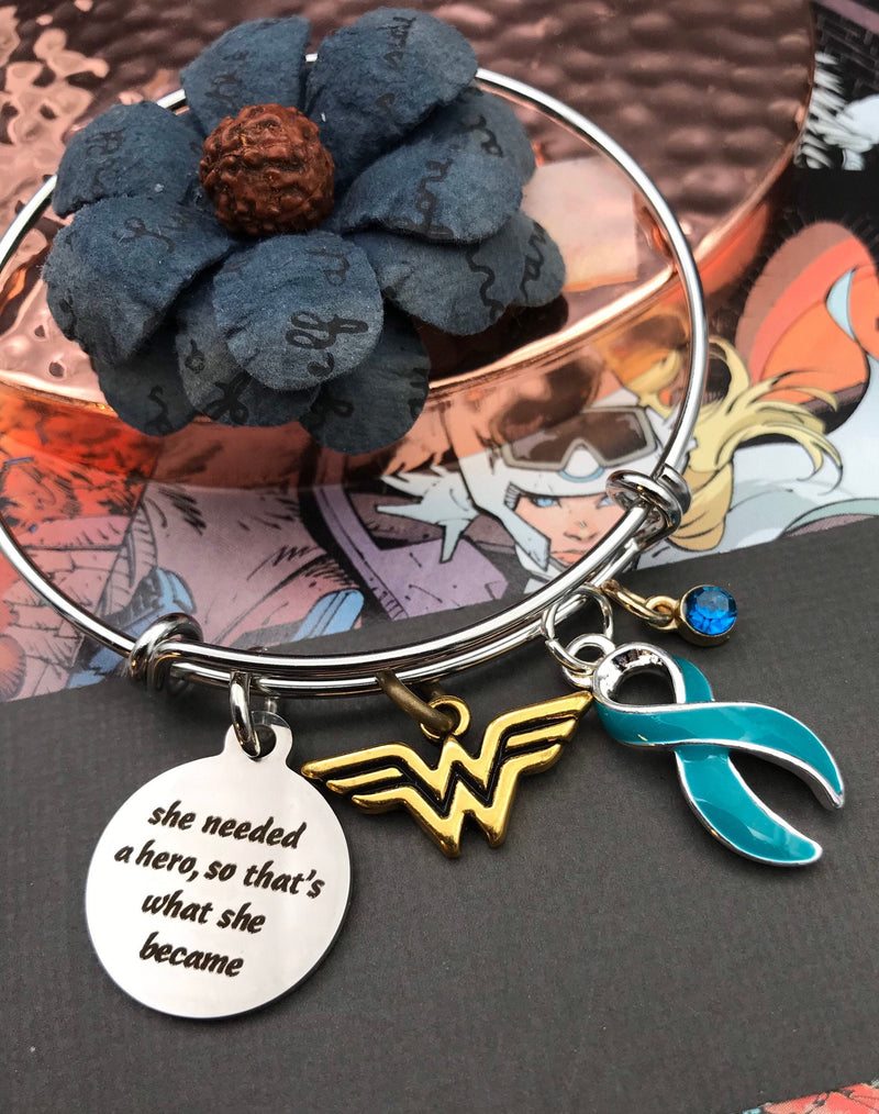 Teal Ribbon Charm Bracelet - She Needed A Hero, So That's What She Became - Rock Your Cause Jewelry